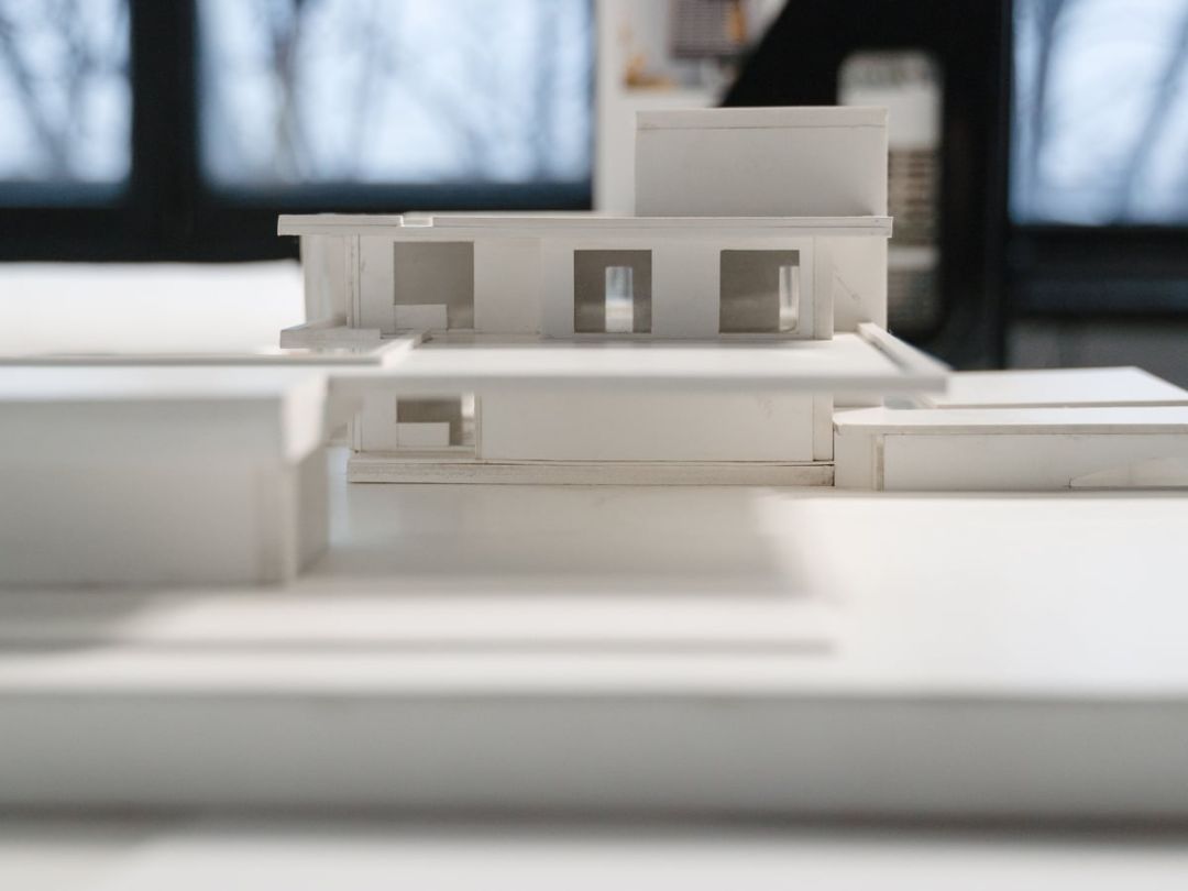 Weisses Architekturmodell eines Wohnhauses mit Flachdach auf einer hellen Fläche
